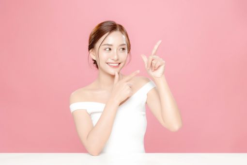 横を指さす女性