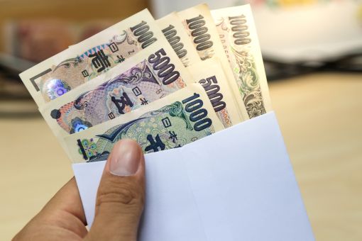 お金を封筒から出す女性