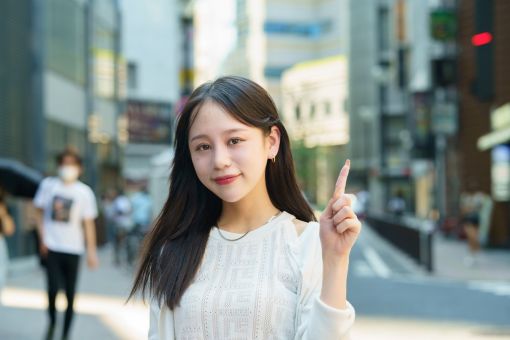 人差し指を立てる女性